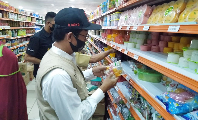 Petugas gabungan saat mengecek barang-barang yang dijual di salah satu supermarket.