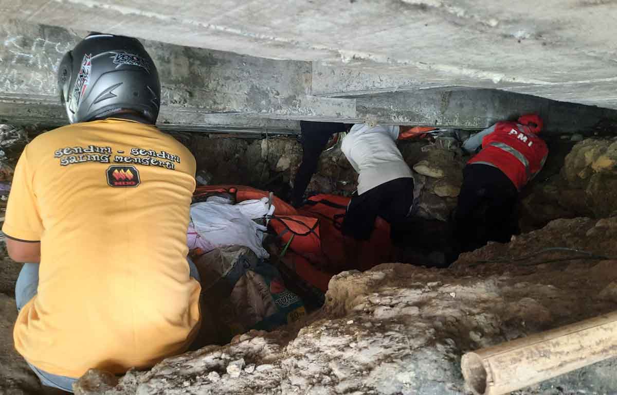 Petugas saat mengevakuasi mayat yang diduga ODGJ di kolong jembatan.