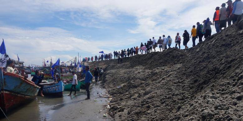 TOLAK REKLAMASI: Warga berbaris di gunungan pasir Pulau G saat penyegelan pulau, belum lama ini. foto: kompas.com
