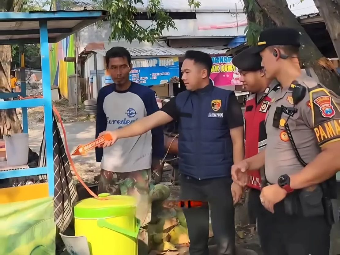 Polisi saat melakukan olah TKP pencurian tas milik pedagang es degan di Lamongan