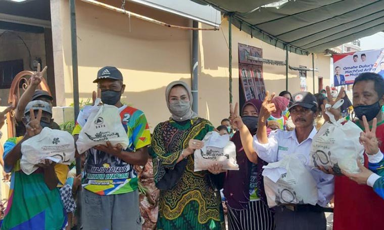 Plt. Ketua Partai Demokrat Surabaya, Lucy Kurniasari, sedang membagikan paket bantuan diduga dari BNPB dalam sebuah acara kampanye. foto: ist.