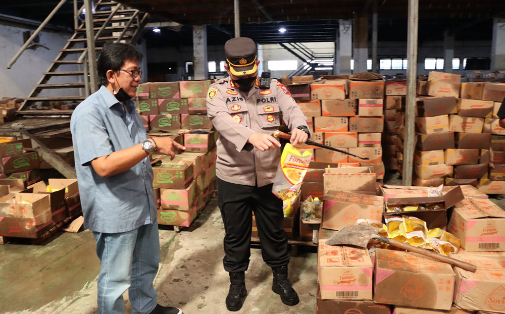 Kapolres Gresik AKBP Azis saat mengambil salah satu minyak goreng yang kemasannya rusak. foto: IST./ BANGSAONLINE