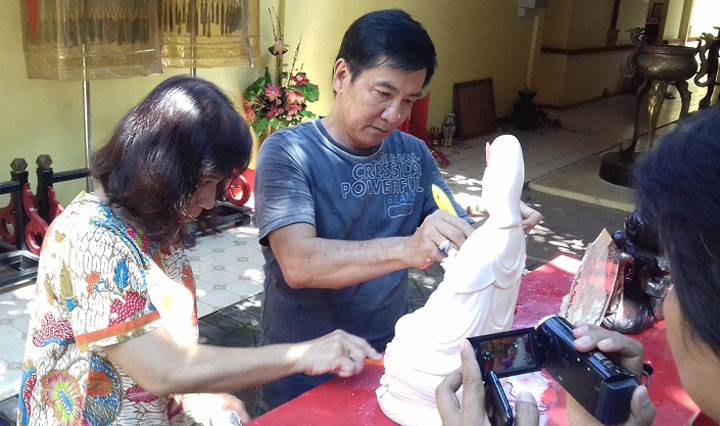 Pengurus Tempat Ibadat Tri Dharma (TITD) Kota Probolinggo saat memandikan puluhan patung Dewa. 
