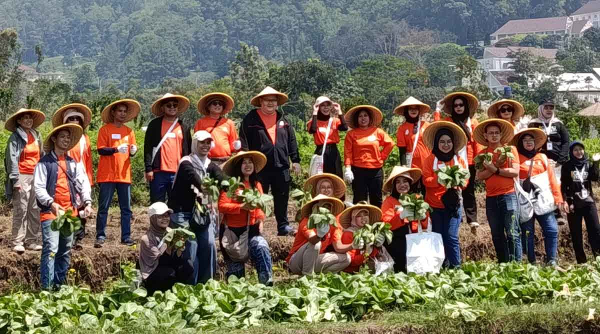 Kelompok Tani Makmur Trunojoyo Kelurahan Songgokerto foto bersama petugas dari Sea Bank usai panen sayuran.