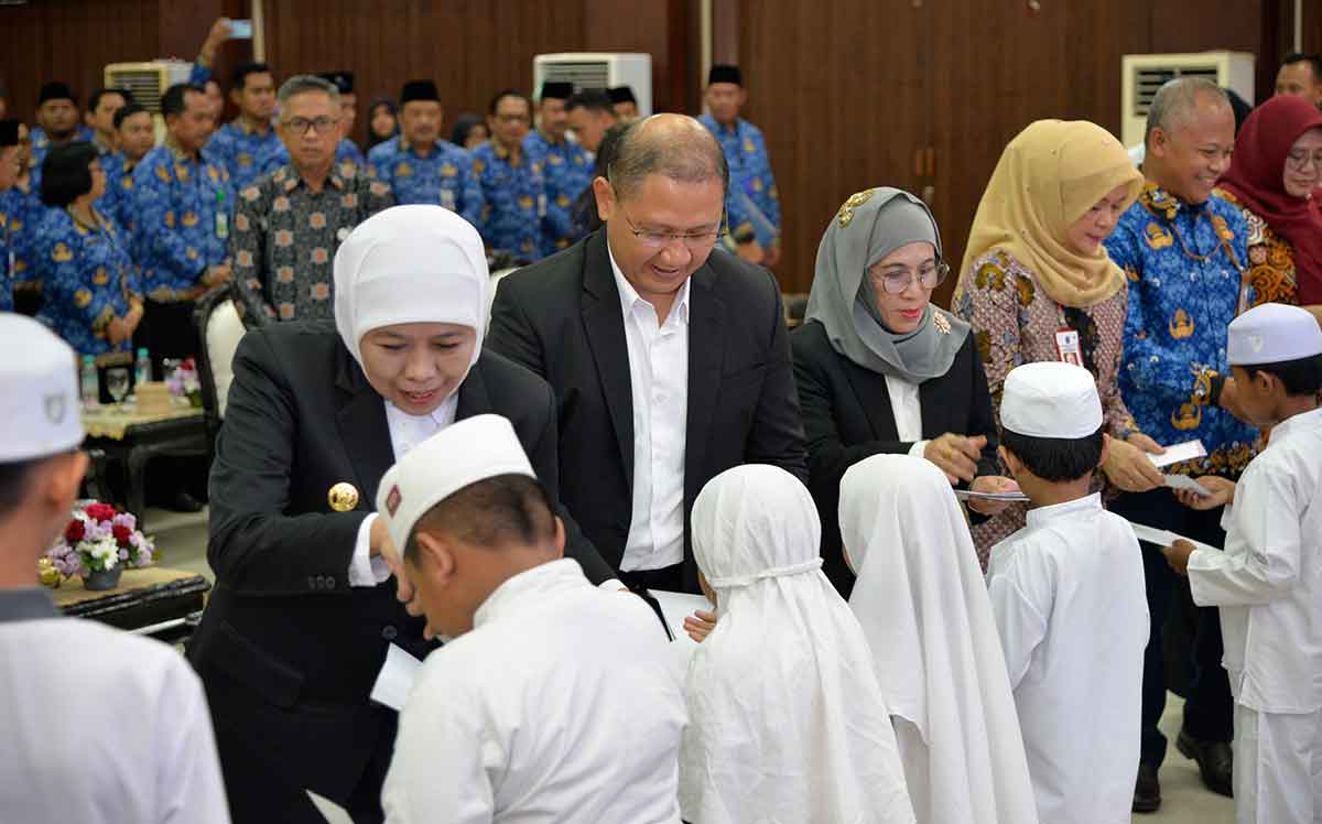 Gubernur Khofifah bersama Kepala Dindik Jatim saat menyalurkan santunan ke anak-anak.