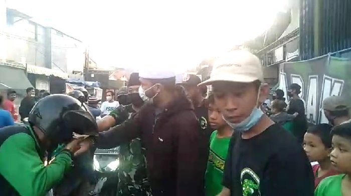 Para Bonek-Bonita saat membagikan takjil nasi bungkus dan jajanan ke sejumlah pengendara sepanjang jalan kawasan bekas lokalisasi terbesar se-Asia Tenggara tersebut, Senin (10/5/2021).