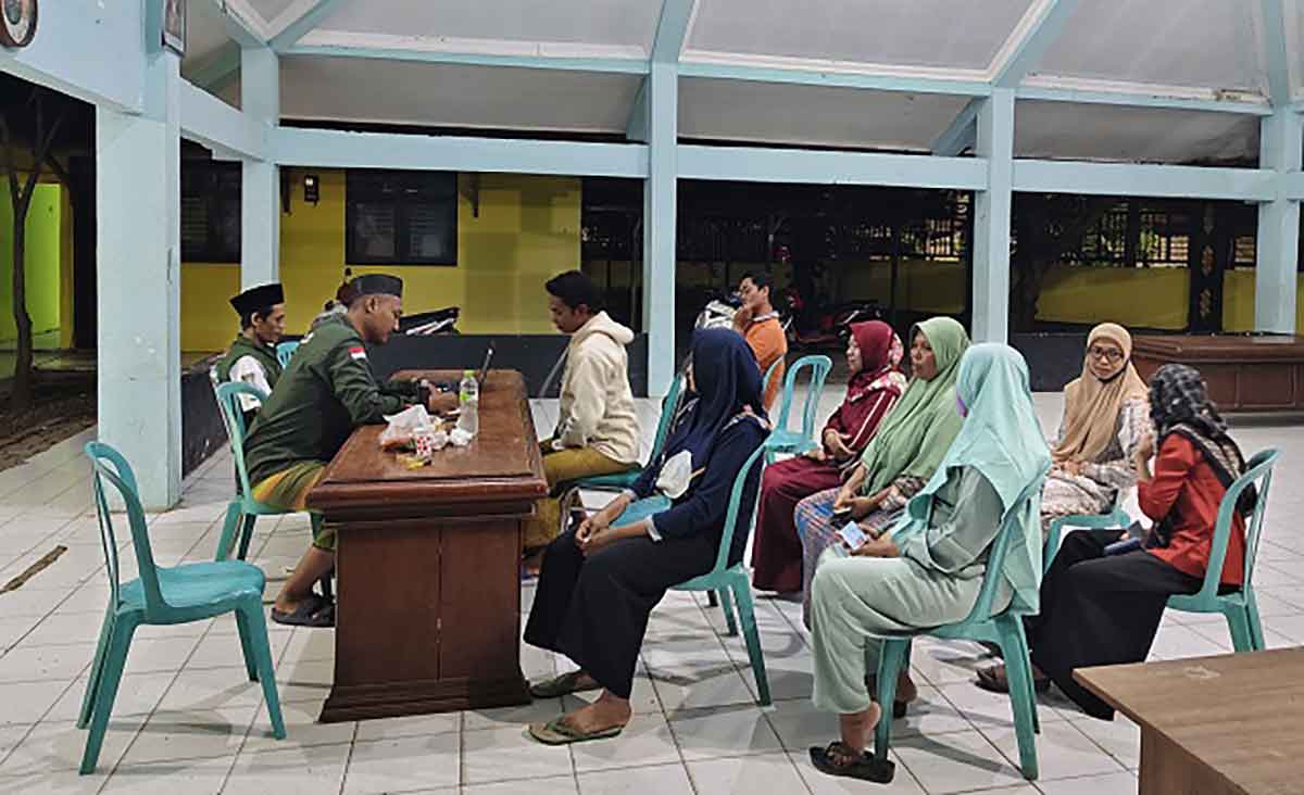 Ketua BPD Temaji, Miftahul Mubarok, saat melakukan penyaluran bantuan di balai desa. Foto: Ist