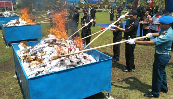 DIBAKAR: Sekitar 18 juta batang rokok ilegal dimusnahkan di halaman Kanwil DJBC Jatim I, Jl Raya Juanda, Sidoarjo, Selasa (9/2). foto: catur andy/ BANGSAONLINE