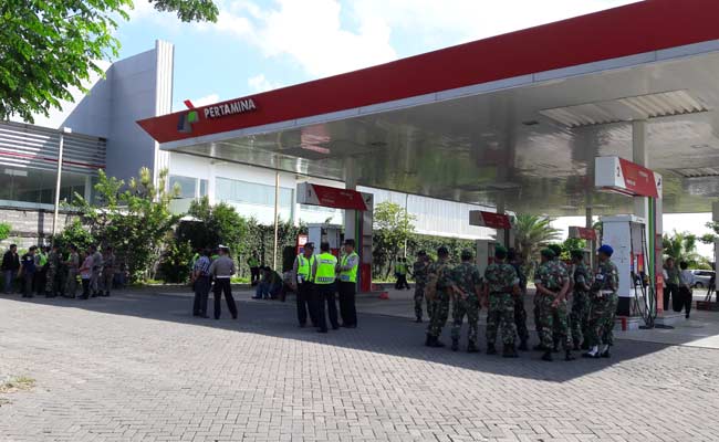 LANCAR: Aparat kepolisian dan TNI saat menjaga jalannya eksekusi SPBU milik mantan Dirut RSUD. foto: syuhud/ BANGSAONLINE