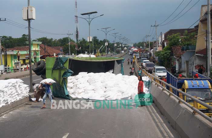 Muatan tepung bahan roti sebanyak 10 ton tumpah dari gandengan dan menutup jalur flyover Peterongan dari arah Surabaya – Madiun. foto: RONY S/ BANGSAONLINE