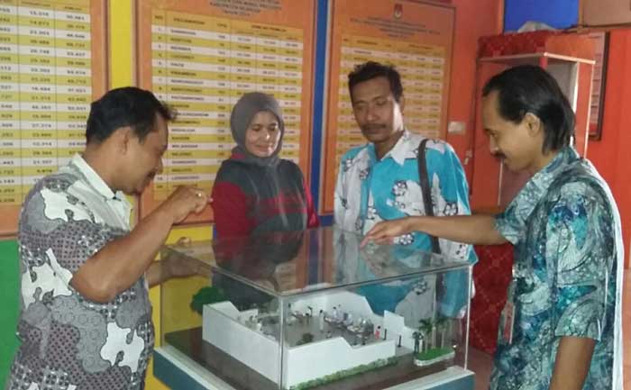 Ketua KPU Nganjuk Agus Rahman Hakim menerangkan maket simulasi proses pemungutan suara di RPP Kendalisada kepada Ketua Panwaslih Nganjuk. foto: BAMBANG/ BANGSAONLINE