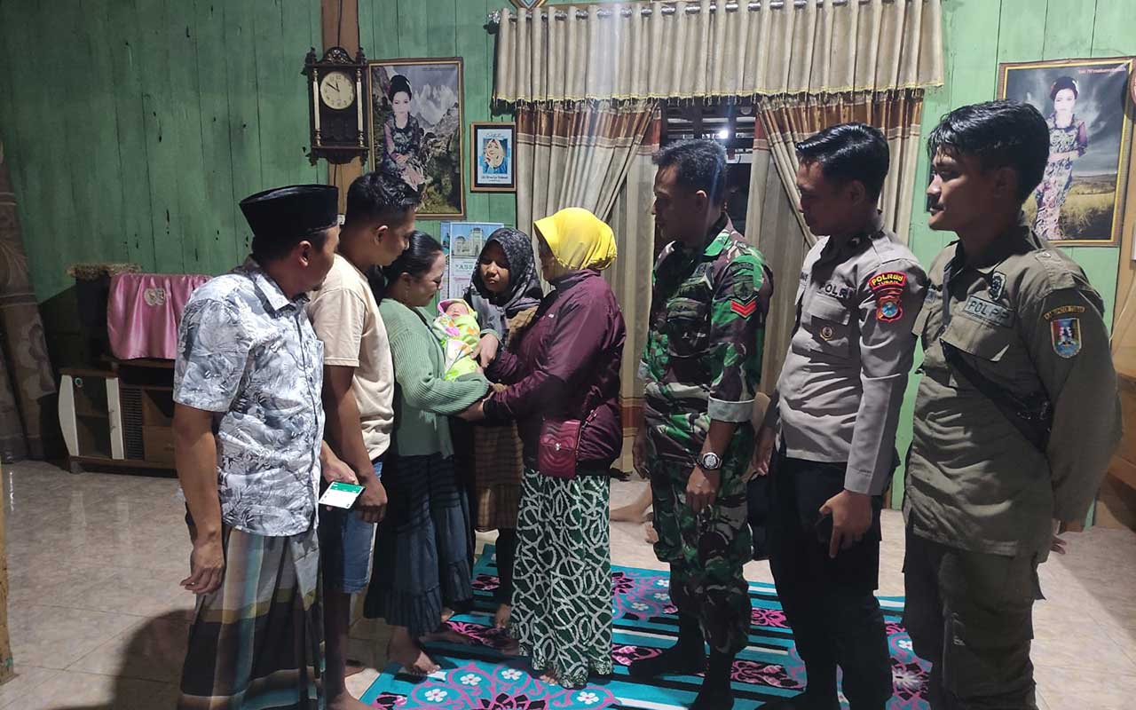 Warga setempat dan anggota TNI-Polri saat melihat bayi yang dibuang oleh pria yang menggunakan mobil di depan Musala An-Nur Tuban.