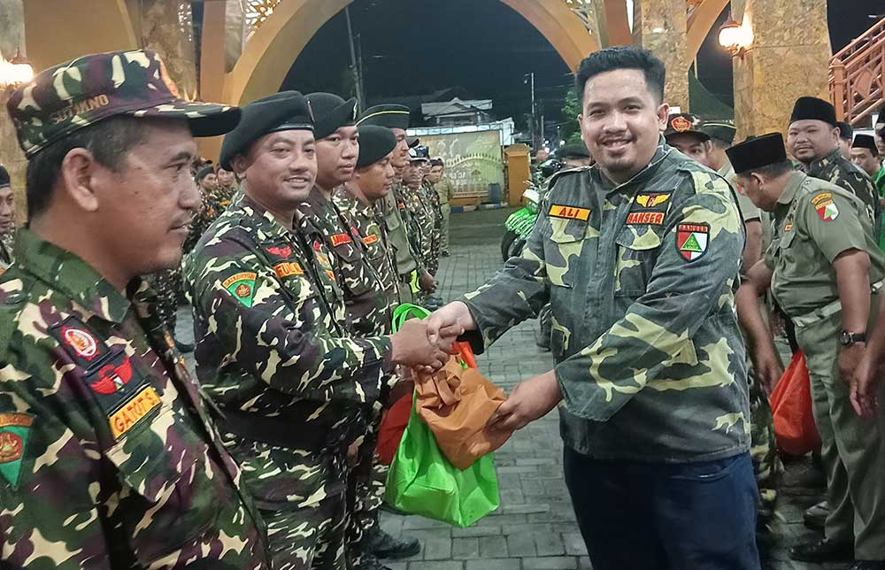 Ali Mannagalli saat membagikan bantuan logistik kepada kader Banser Sidoarjo.
