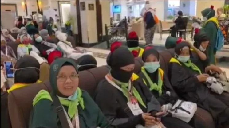 Jemaah haji asal Lamongan mengenakan mawar di kerudung sebagai penanda agar tidak terpisah dari rombongan