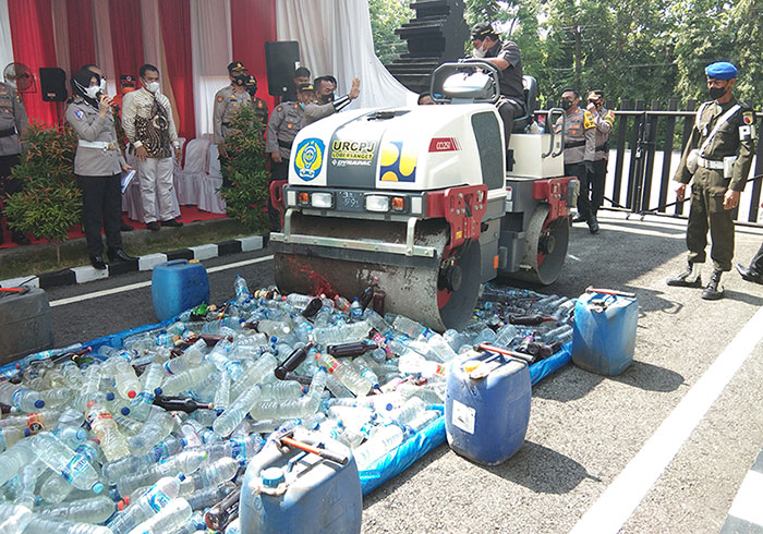 Plt Bupati Nganjuk, Marhaen Jumadi, saat menjalankan mobil penggilas untuk menghancurkan ribuan botol miras.