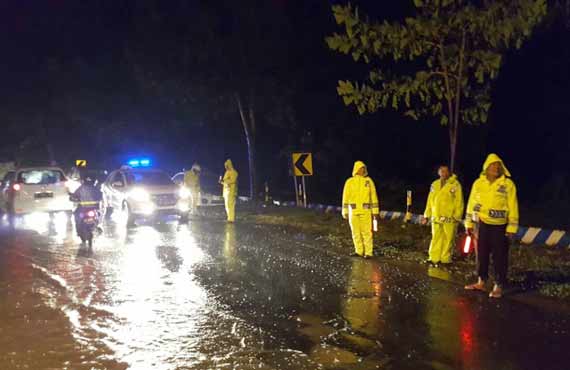 Tim siaga Polres Situbondo, saat melakukan pengaturan arus lalu lintas di jalan raya Pasir Putih Situbondo yang terendam banjir.
