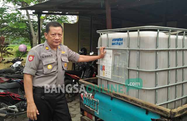 Kapolsek Semanding, AKP Desis Susilo menunjukkan arak baceman yang hendak dibawa kabur pelaku. foto: GUNAWAN/ BANGSAONLINE