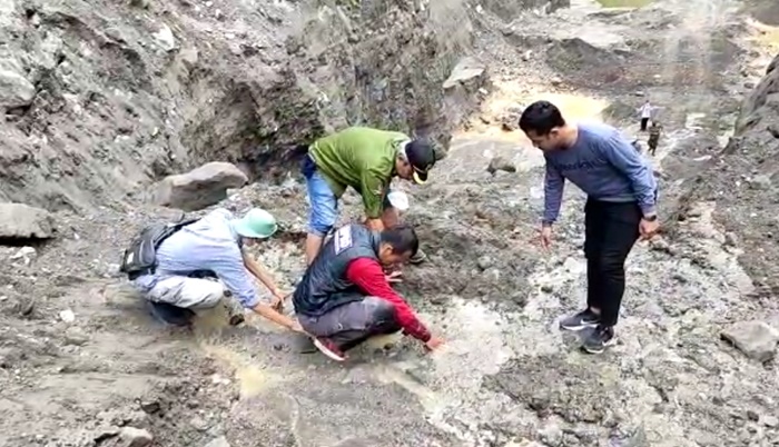 Kaki kiri Kepala Seksi Kedaruratan Bencana BPBD Kabupaten Kediri, Johan Marasponda (pakai rompi), saat terperosok dan terjepit pasir berlumpur dan berhasil diangkat setelah dibantu oleh kawan-kawan satu Tim termasuk Wakil ADM Perhutani KPH Kediri, Beny Mukti. foto: MUJI HARJITA/BANGSAONLINE
