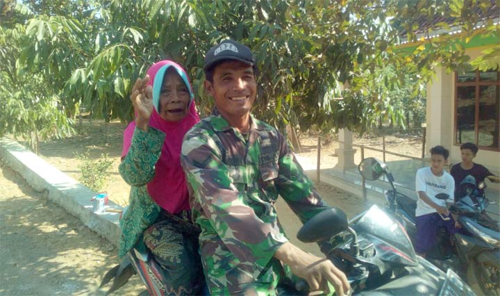 Sertu Iksan saat hendak mengantar nenek warga Desa Kecamatan Ketapang.
