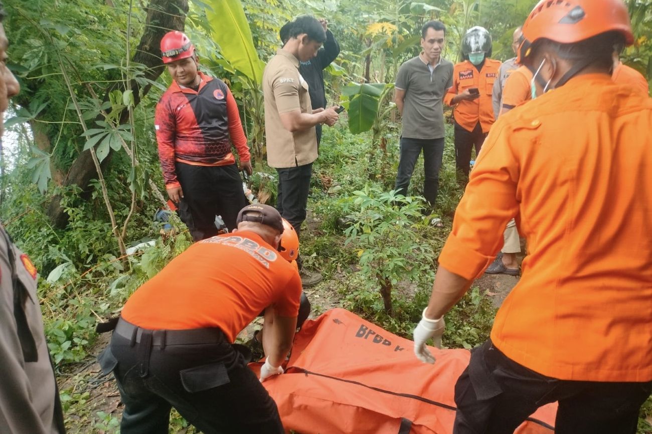 Petugas BPBD Surabaya saat mengevakuasi jasad pria misterius yang ditemukan terapung di sungai kawasan Barata Jaya