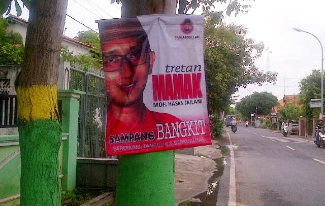 Gambar salah satu kandidat ditempel di pohon.