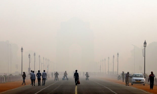 Orang-orang berjalan di depan kabut asap menutupi peringatan perang Gerbang India di Delhi, India.
