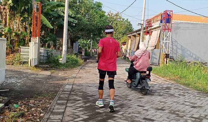 Warga tengah berolahraga dan berkendara di jalan paving Desa Kembangan. Foto: SYUHUD/ BANGSAONLINE
