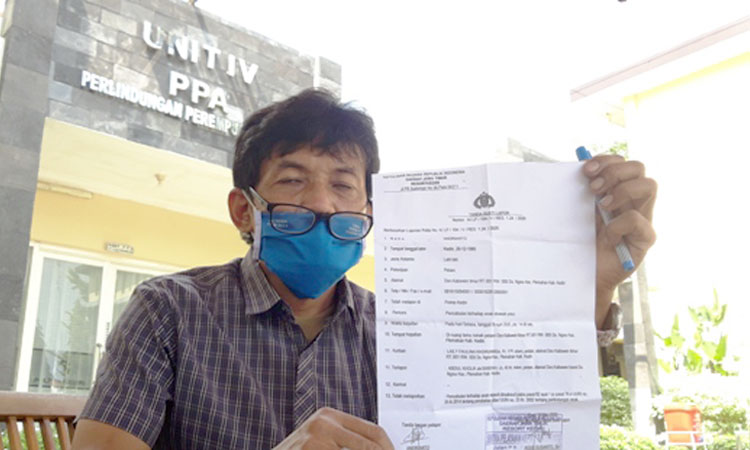 M. Karim Amrulloh, S.H., Kuasa Hukum korban, menunjukan bukti laporan. (foto: Muji Harjita/ BANGSAONLINE)