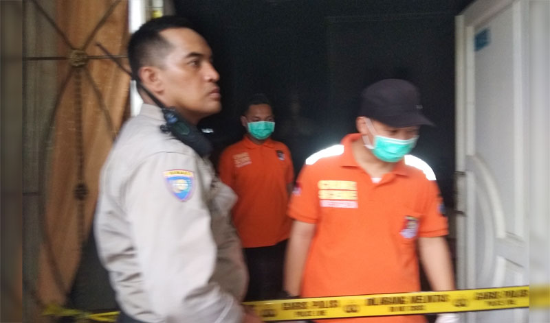 Polisi memasang police line di rumah korban.