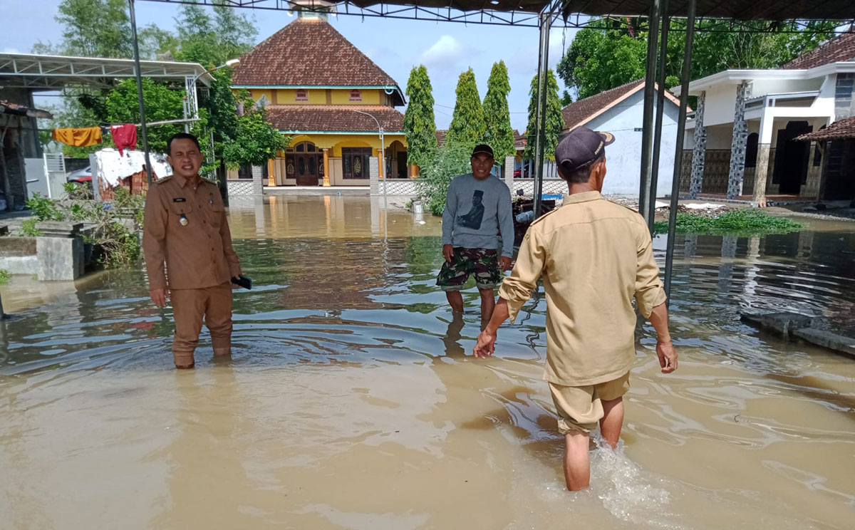 Camat Balongpanggang Muhammad Amri Maulana (kiri) memantau desa di wilayahnya yang terendam banjir. Foto: SYUHUD/ BANGSAONLINE