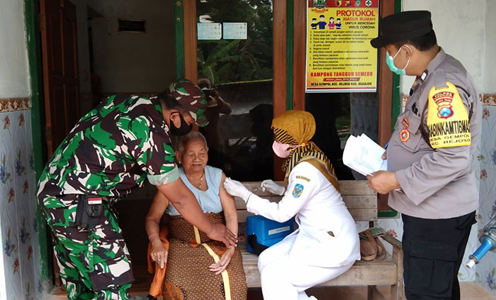 Petugas Bhabinkamtibmas Polres Nganjuk saat meninjau penyuntikkan vaksin Covid-19 pada lansia.