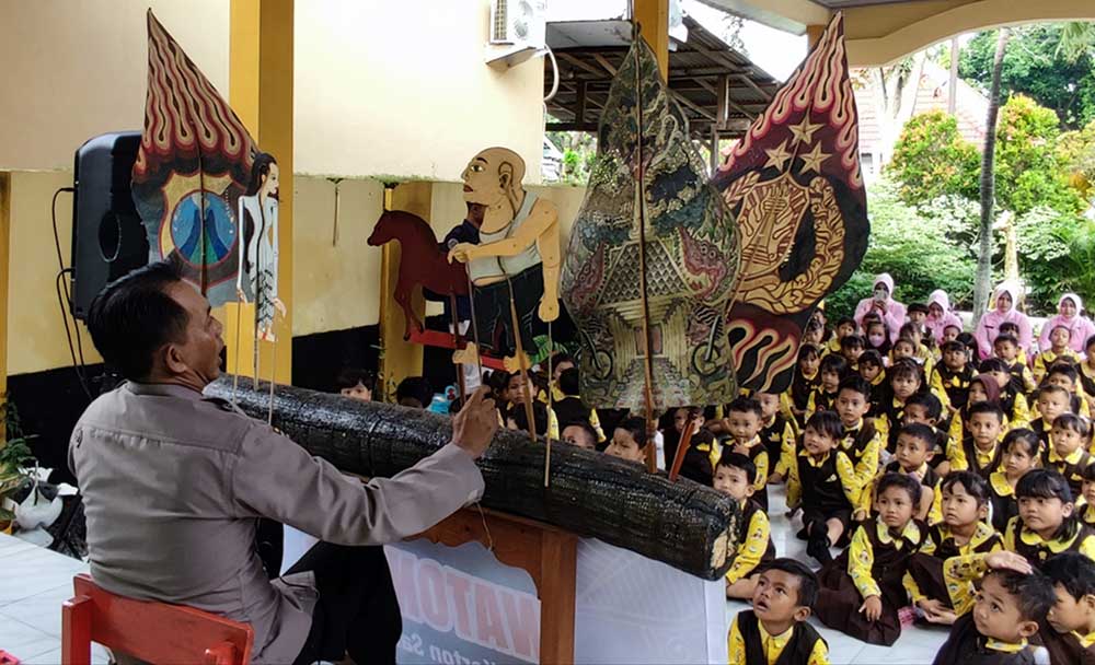 Kapolsek Pare AKP Bowo Wicaksono saat mendalang di hadapan murid TK Kemala Bhayangkara 43 Pare. Foto: MUJI HARJITA/ BANGSAONLINE