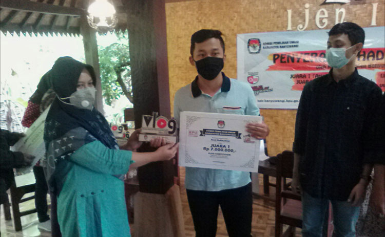 Ketua KPU Banyuwangi Dwi Anggraeni menyerahkan hadiah juara lomba vlog di Ijen Isun Banjarsari, Kecamatan Glagah, Kabupaten Banyuwangi. (foto: ist)