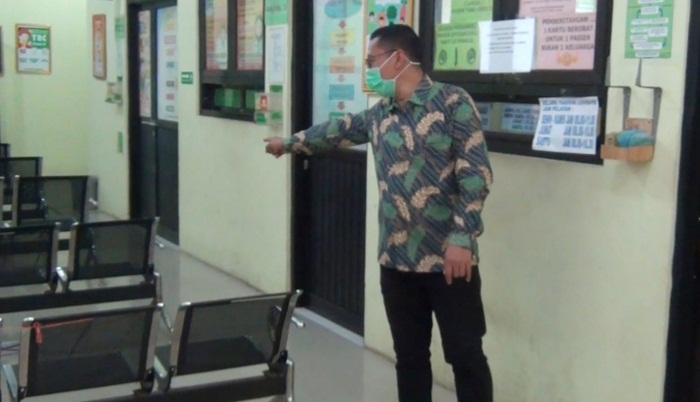 Nampak pegawai puskesmas sedang menunjukkan deretan bangku tunggu pasien yang hilang dicuri orang.