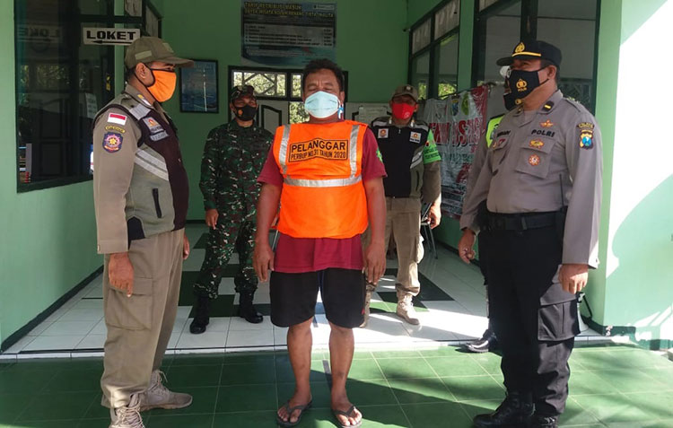 Seseorang terjaring razia operasi yustisi di Jalan Soekarno-Hatta Trenggalek. (foto: HERMAN/BANGSAONLINE)