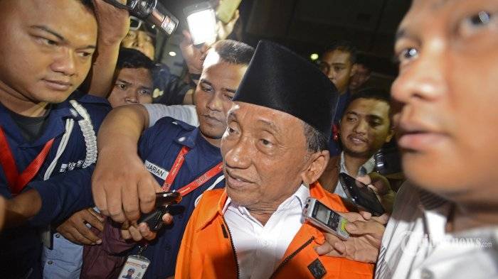 Mantan Bupati Bangkalan yang juga Ketua DPRD Bangkalan, Fuad Amin Imron (tengah) dengan mengenakan baju tahanan keluar dari gedung Komisi Pemberantasan Korupsi (KPK), Jakarta Selatan, Selasa (2/12/2014). Fuad resmi menjadi tersangka dan ditahan KPK dalam kasus dugaan suap terkait jual beli pasokan gas alam untuk pembangkit listrik di Gresik dan Gili Timur, Bangkalan, Madura, Jawa Timur. ANTARA FOTO/Fanny Octavianus /tribunnews.com