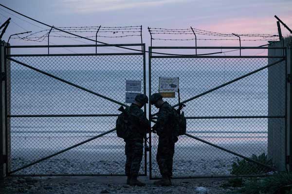 Tentara Korea Selatan mengunci pintu masuk ke pantai di pulau Yeonpyeong, dekat garis batas utara perbatasan laut dengan Korea Utara. Ed Jones / AFP - Getty Images file