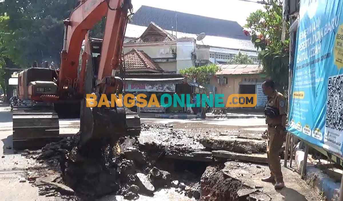 Ekskavator saat melakukan pengerukan untuk pembangunan gorong-gorong. Foto: BAMBANG DWI JULIANTO/BANGSAONLINE