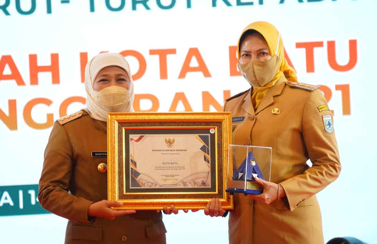 Gubernur Jawa Timur, Khofifah Indar Parawansa, saat menyerahkan penghargaan WTP kepada Wali Kota Batu, Dewanti Rumpoko, di Hotel Bumi Surabaya.
