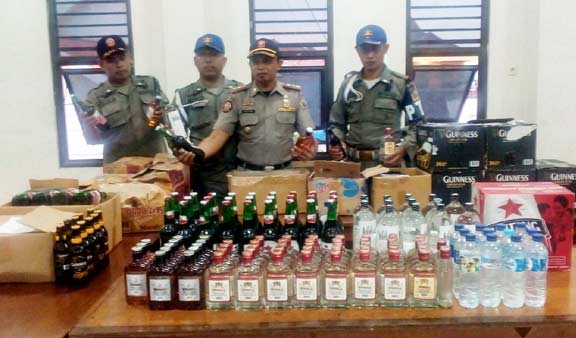 Kasi Ops Satpol PP ketika menunjukkan barang bukti ratusan botol miras. foto: syuhud/ BANGSAONLINE