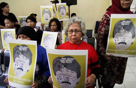 Aktivis KASUM membentangkan poster saat menghadiri sidang pembacaan putusan pembebasan bersyarat kepada Pollycarpus di PTUN, Jakarta pada 29 Juli 2015 silam.