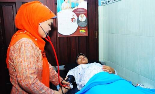 INOVATIF- Bidan Suhartatik Qomariyatun saat memeriksa pasien ibu hamil, di tempat praktiknya, di Dusun Kalibogo Desa Kaliwates Kecamatan Kembangbahu Lamongan, Kamis (15/5/2014). foto : haris sugianto/BangsaOnline