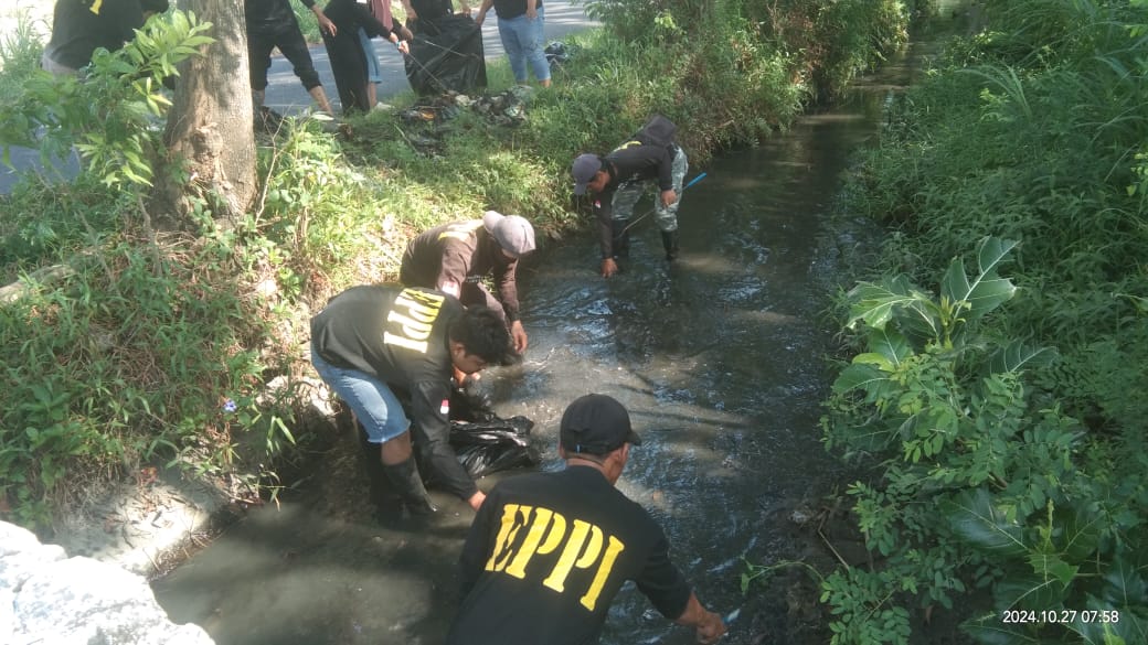 Aktivis lingkungan hidup yang tergabung dalam EPPI saat memunguti sampah di sungai. (Ist).