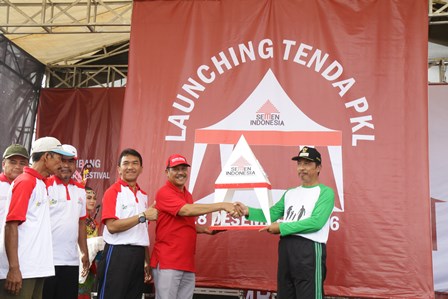 Direktur Produksi Semen Gresik, Prasetyo Utomo (kedua kanan) menyerahkan bantuan 98 tenda dan 15 shelter untuk Paguyuban PKL Alun-Alun Rembang secara simbolis kepada Bupati Rembang, Abdul Hafidz (kanan) di acara Rembang Culinary Festival. foto: syuhud/ bangsaonline