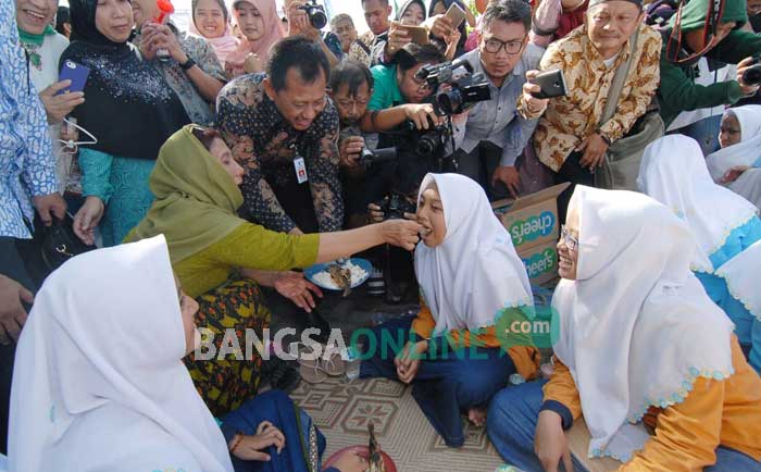Menteri Kelautan dan Perikanan RI, Susi Pudjiastuti saat menyuapi seorang santri. foto: RONY S/ BANGSAONLINE