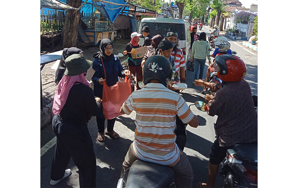 Para seniman yang tergabung dalam Forum Pamong Kebudayaan (FPK) Kabupaten Pasuruan saat pembagian nasi bungkus di wilayah Bangil.