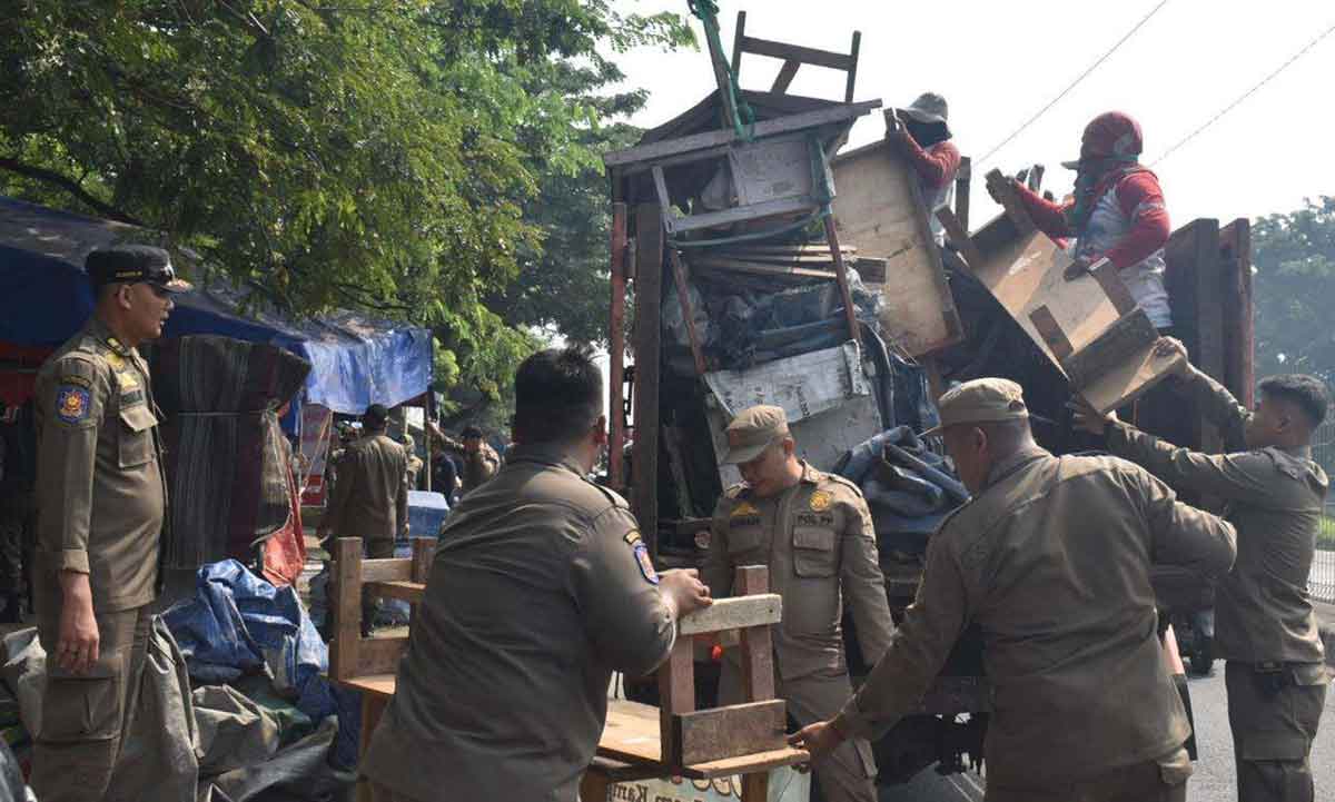Petugas dari Satpol PP Surabaya saat menertibkan PKL di sekitar Jembatan Suramadu.