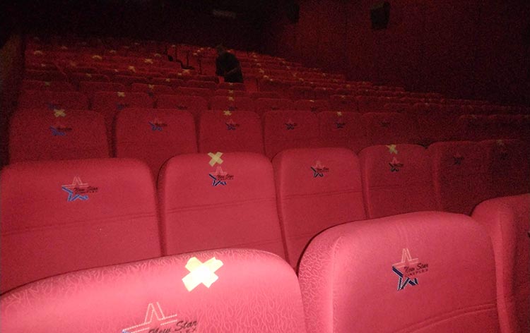 Tempat duduk dalam bioskop yang diberi tanda silang untuk menjaga jarak antar pengunjung. (foto: TRIWIYOGA/ BANGSAONLINE)