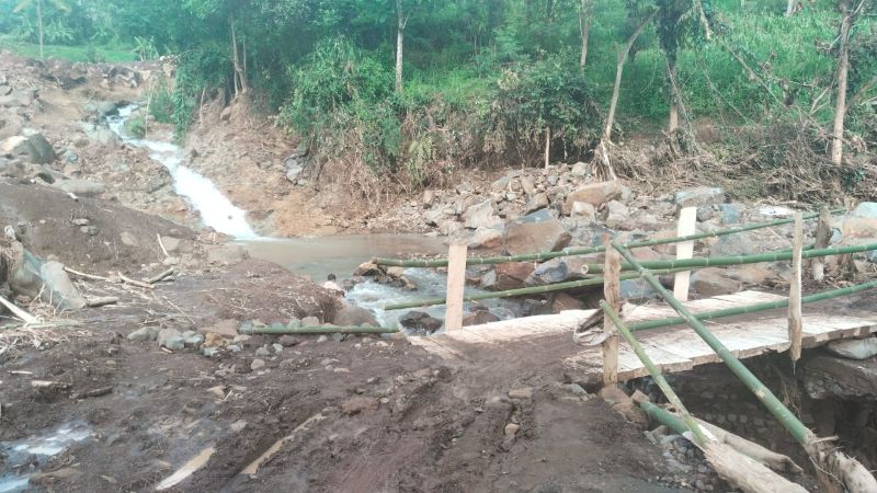 Jembatan kayu hasil swadaya warga sebagai pengganti sementara jembatan yang rusak akibat diterjang banjir