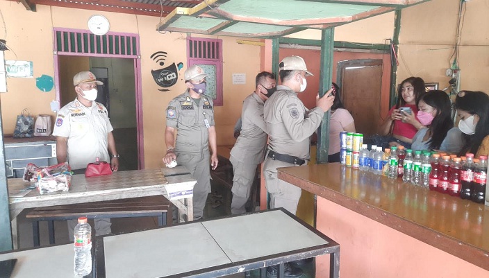 Petugas Satpol PP Gresik ketika menertibkan penjaga warung di Telaga Ngipik. foto: SYUHUD/ BANGSAONLINE.com